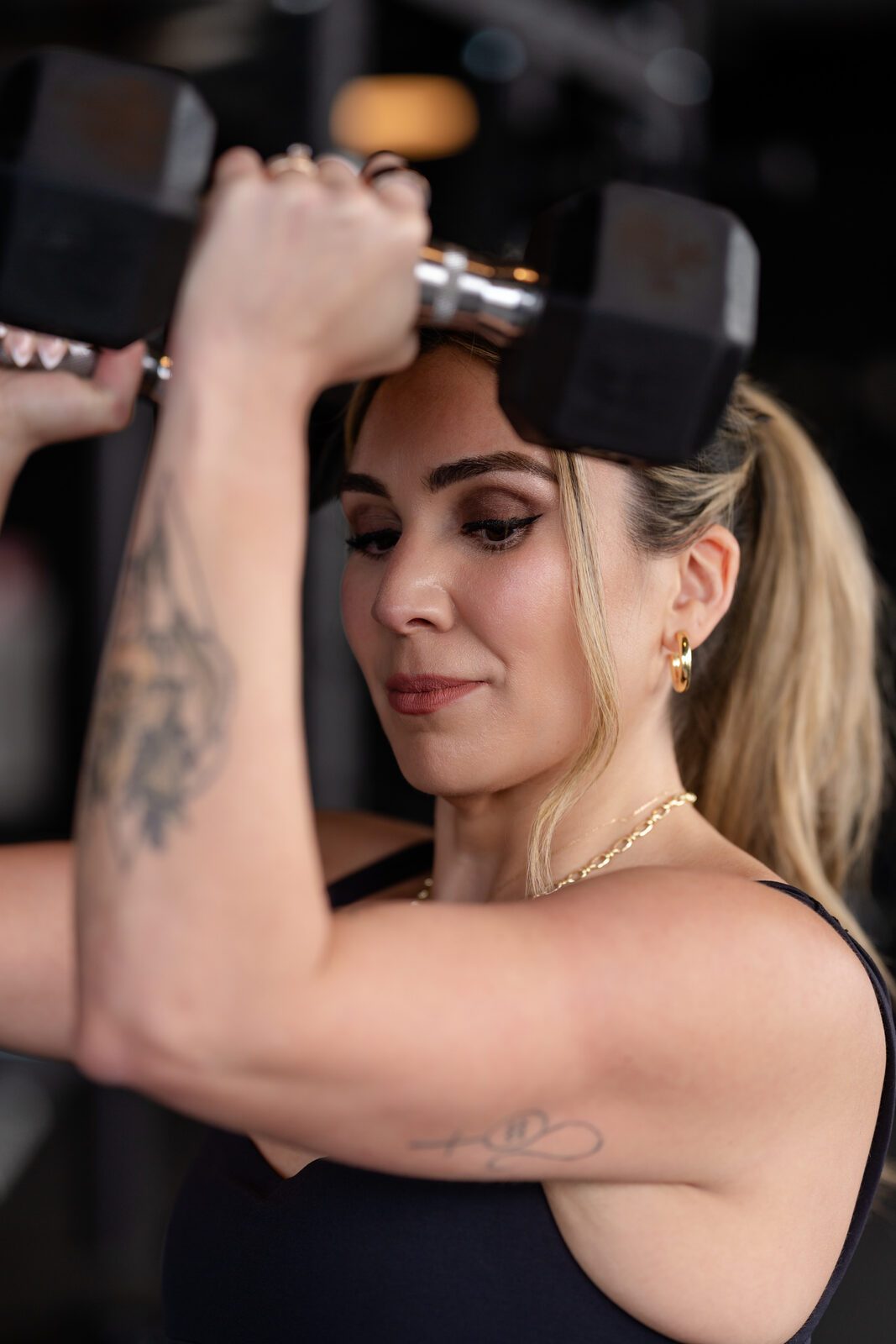 Close-up of Carolina pressing a dumbbell overhead